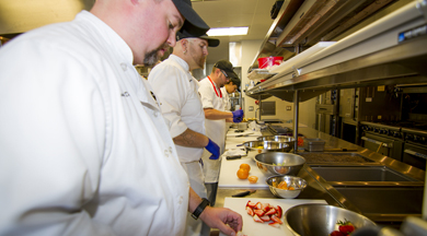 Student chefs cooking in the culinary kitchen.  