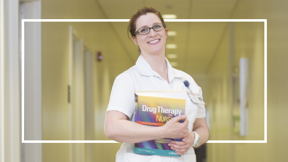 Nursing student posing with Drug Therapy book.