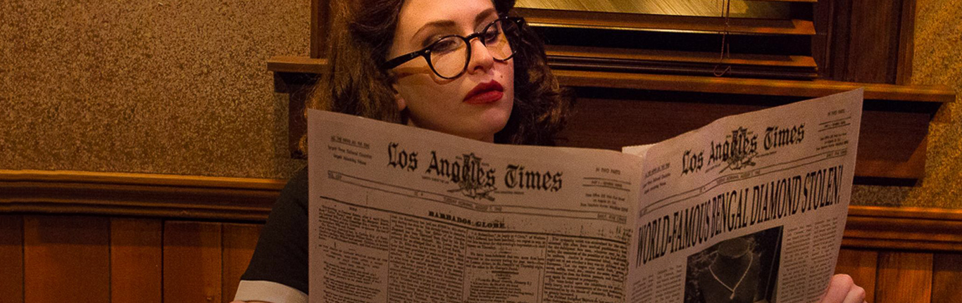 Actress reading the newspaper in a play.