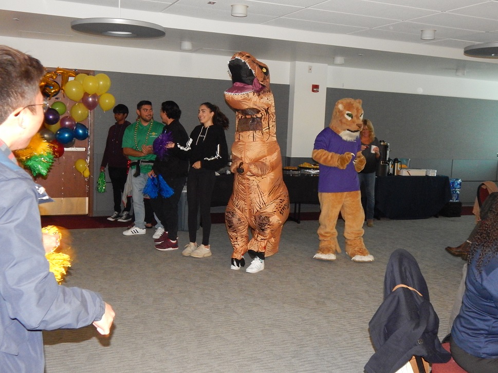 a person in an inflatable dinosaur outfit dancing at the LEAP team party
