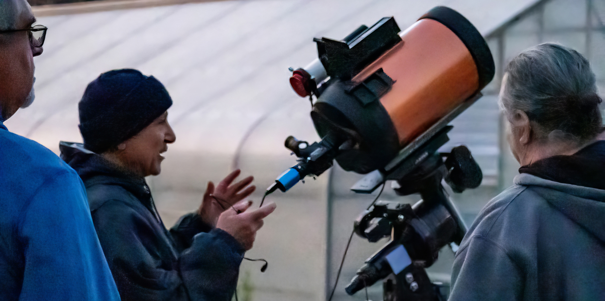 A Star Party participant demonstrates use of a high-powered telescope.