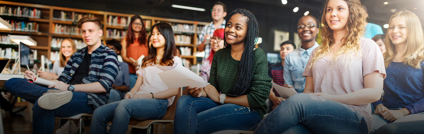 Group of smiling college students seated in a classroom.