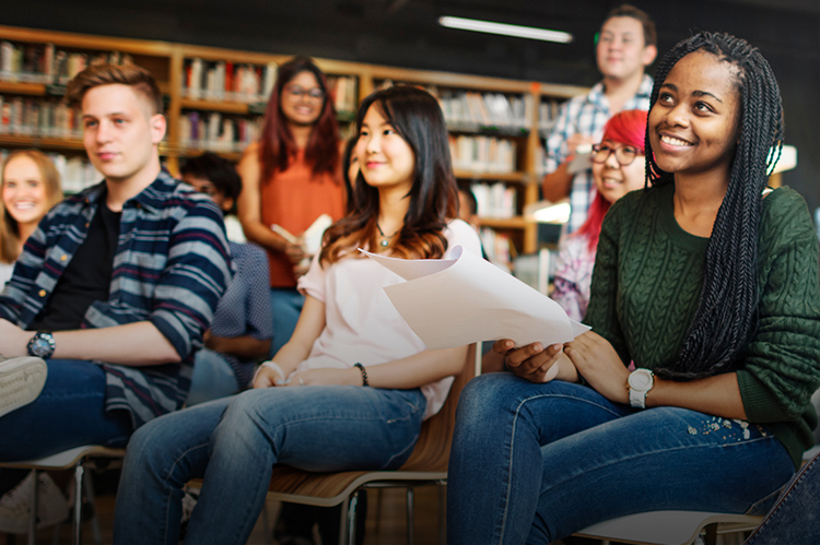 Group of smiling college students seated in a classroom.