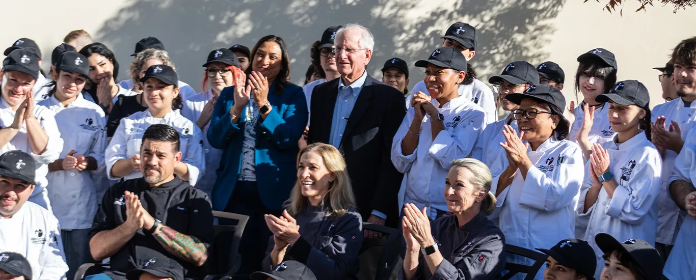 Culinary arts faculty and students applaud Gary Cusumano (center) for his $1 million gift honoring the life and legacy of educator Diana Cusumano.