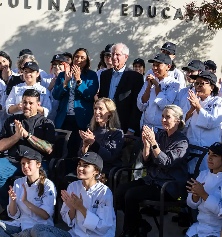 Culinary arts faculty and students applaud Gary Cusumano (center).
