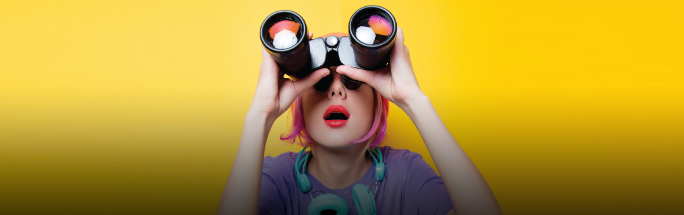 Female student gazing upward with binoculars.