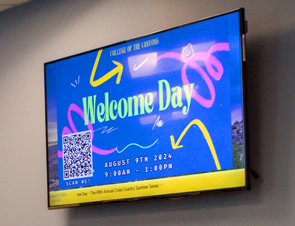A wall-mounted display monitor promotes a campus event.