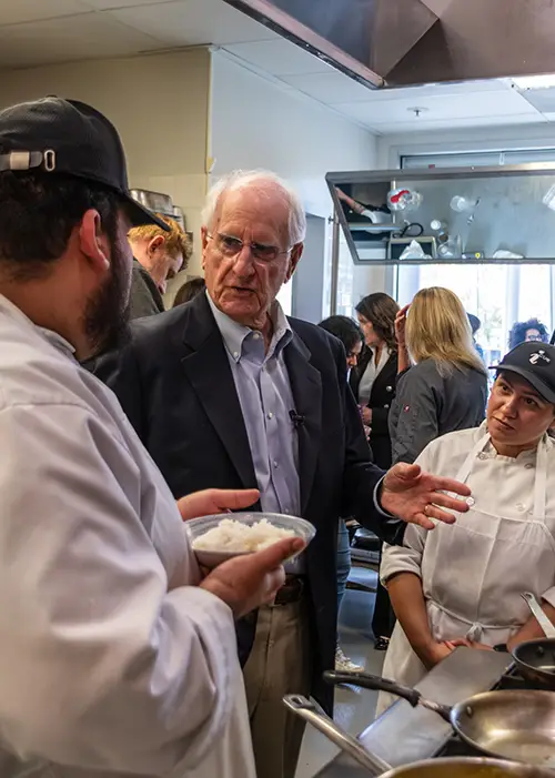 Gary Cusumano (center) speaks with culinary arts students.