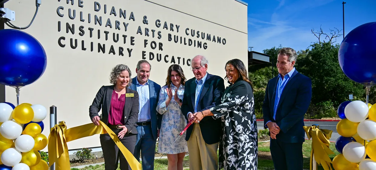 Gary Cusumano cuts the ceremonial ribbon with members of his family and the college community.