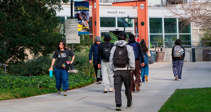 Students walk on a pathway toward Hasley Hall.