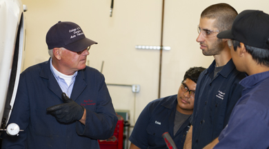 Faculty talking to automotive students. 