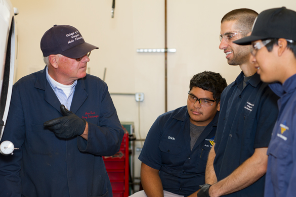 Auto mechanic students listening to instructor. 