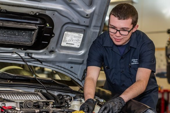 Automotive student working under the hood.