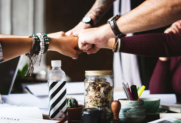 Buisness co-workers fist-bumping.