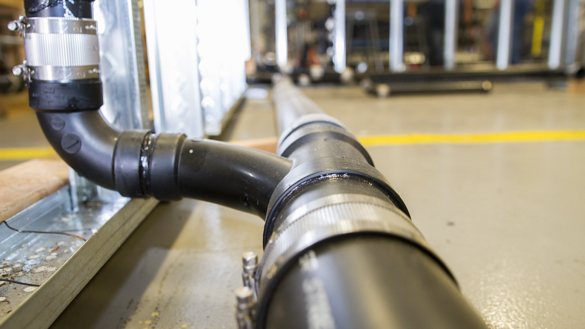 Plumbing pipes exposed in classroom setting. 