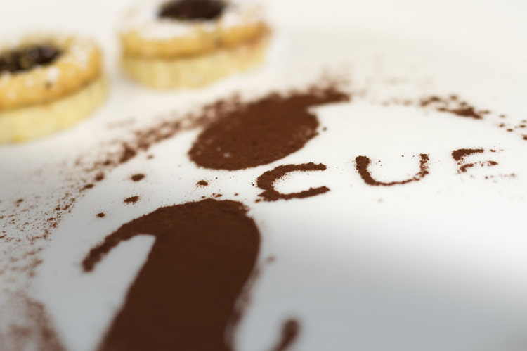 iCUE logo made of dusted cocoa with 2 short bread cookies.