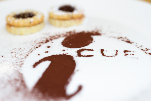 iCUE logo in chocolate dust, with cookies. 