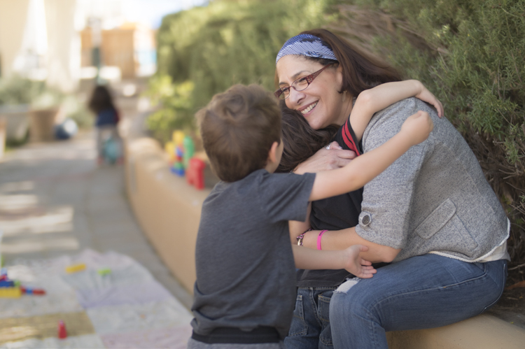 Children hugging their teacher at Early Childhood Education. 