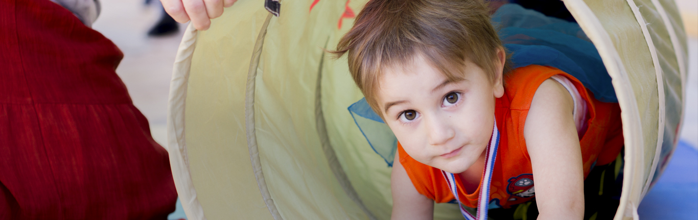 Child playing in a tunnel at the Center for Early Childhood Education. 