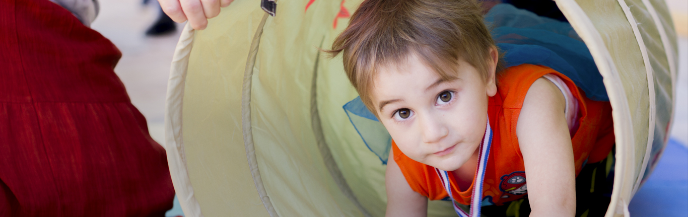 Child playing in a tunnel at the Center for Early Childhood Education. 