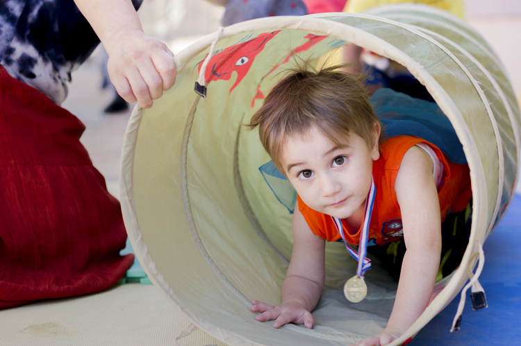 Child playing in a tunnel at the Center for Early Childhood Education. photo © Robin Spurs