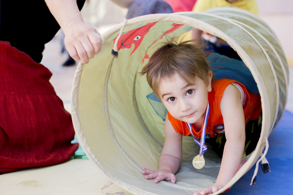 Child crawling through play tunnel.