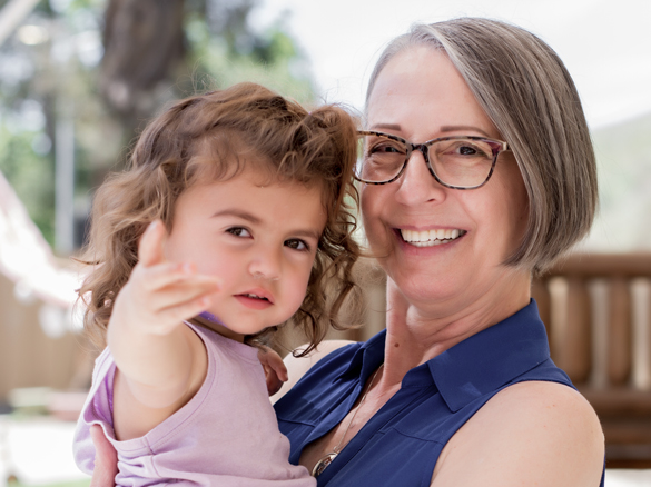 Faculty adult holding child.