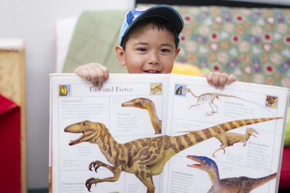 Child reading Dinosaur book at Center for Early Childhood Education.  