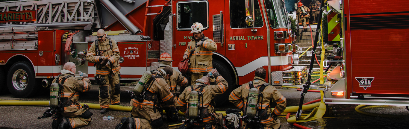 FIre Fighters in full gear, resting from fighting fires.