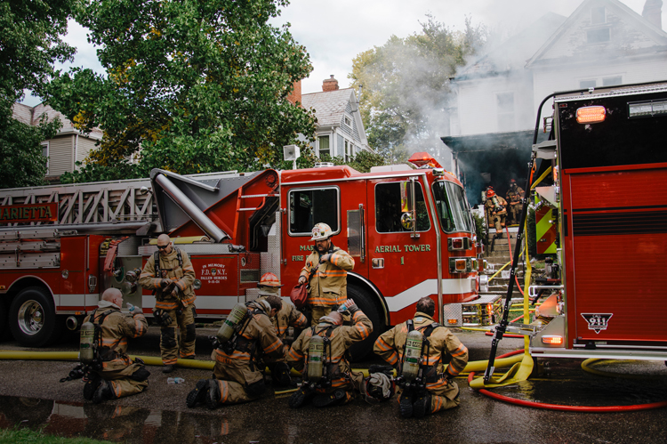 FIre Fighters in full gear, resting from fighting fires.