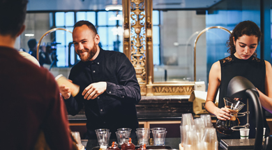 Happy restaurant servers mixing drinks.