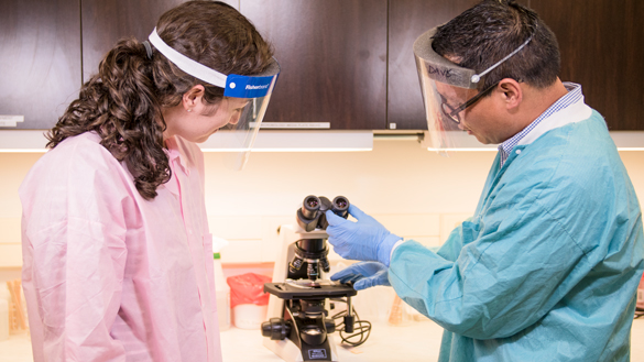 Medical Laboratory Technician student with instructor with microscope.  