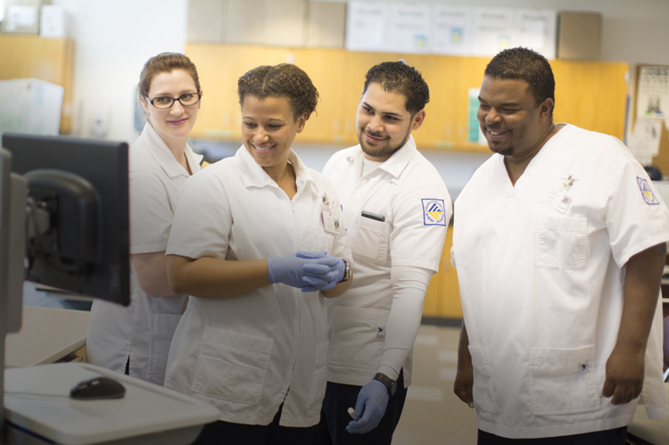 Four nurses looking at computer data.