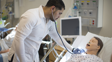 Nursing student with manequin 'patient'.