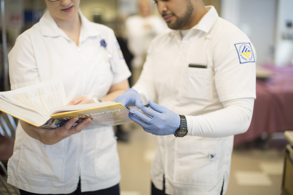 Nursing students reading nursing book.