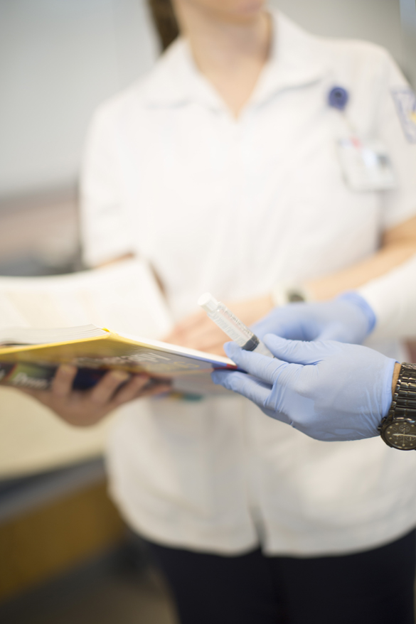 Nursing students looking at nursing book.