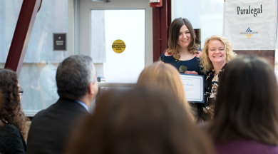 Paralegal graduation ceremony; graduate with faculty. photo © Robin Spurs