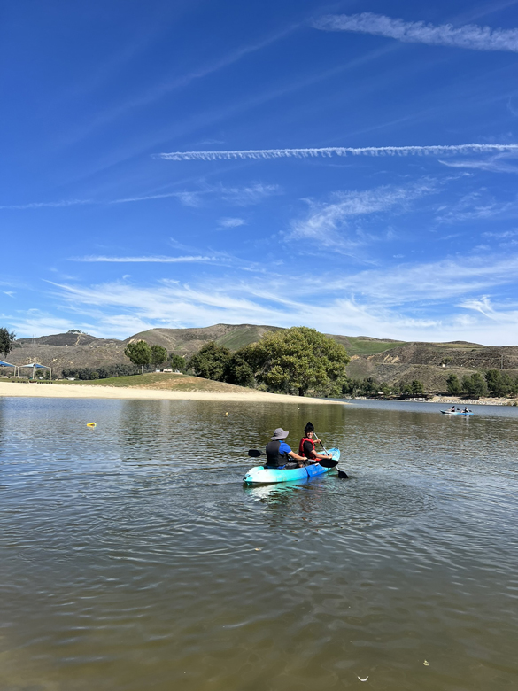 Two students kayaking on lake.