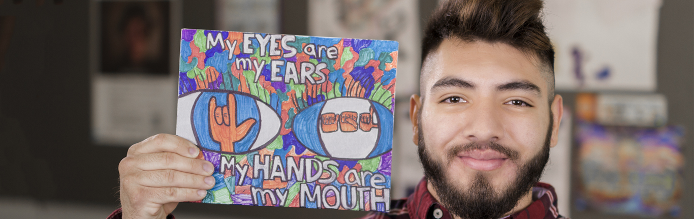 Sign Language student holding encouraging art sign. 