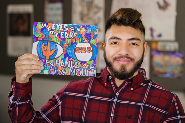 Sign Language student holding encouraging art sign. 