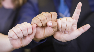 Three hands using sign language.