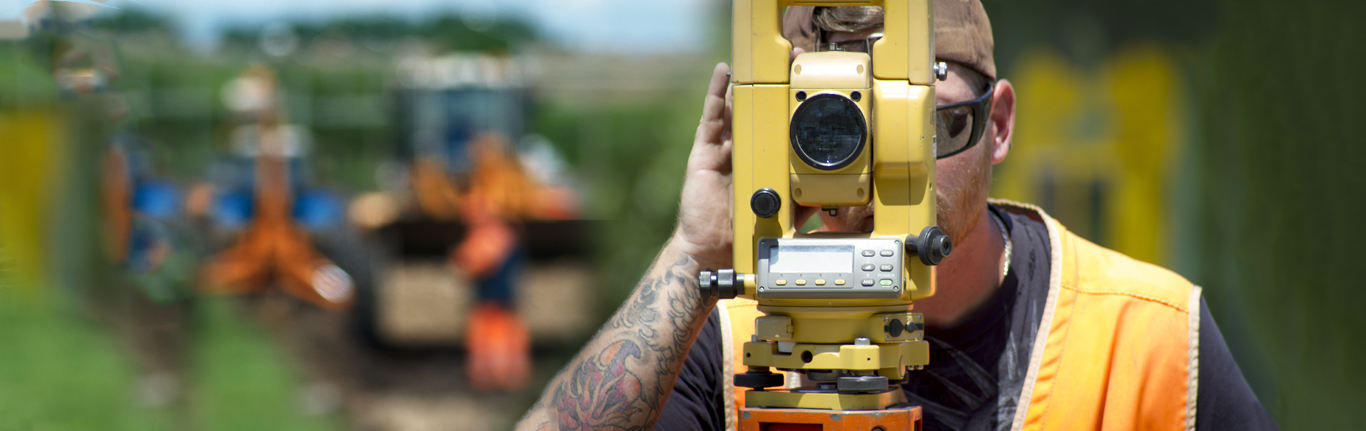  Surveyor looking through surveying equipment. 