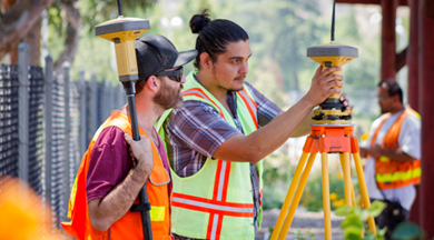 Student surveyors looking through surveying equipment. 