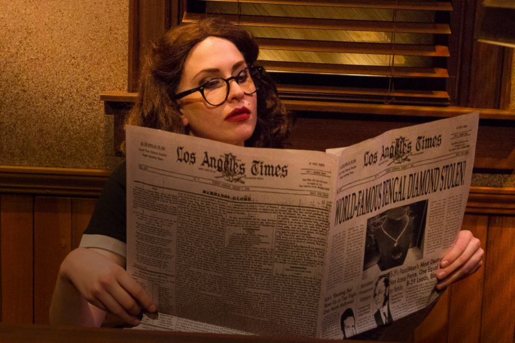 Actress reading the newspaper in a play.