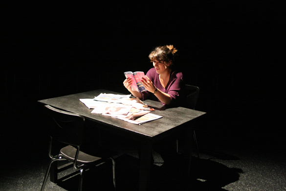 Actor at table reading book.