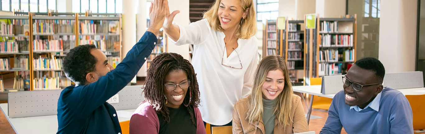 Group of ethnically varied students in a library.