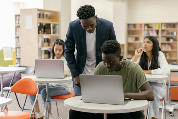 Teacher instructing a student in classroom.