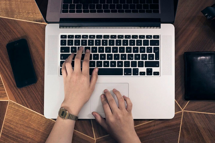  Student hands on laptop keyboard.